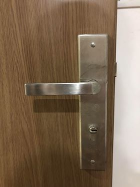 Khóa chìa cơ truyền thống bản rộng lỗi thời trên cửa gỗ cũ mà khách hàng muốn thay thế